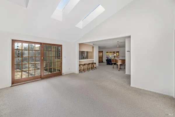 an empty room with furniture and large windows