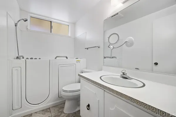 a bathroom with a sink a toilet and a mirror