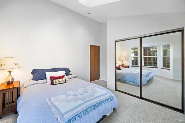a bedroom with a bed and large window