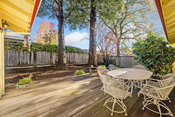 a view of a patio with table and chairs with wooden fence and plants