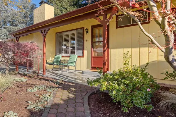 a front view of a house with a yard and potted plants
