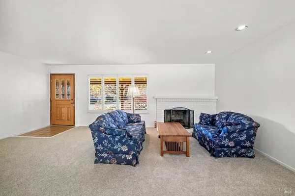 a living room with furniture a fireplace and a large window
