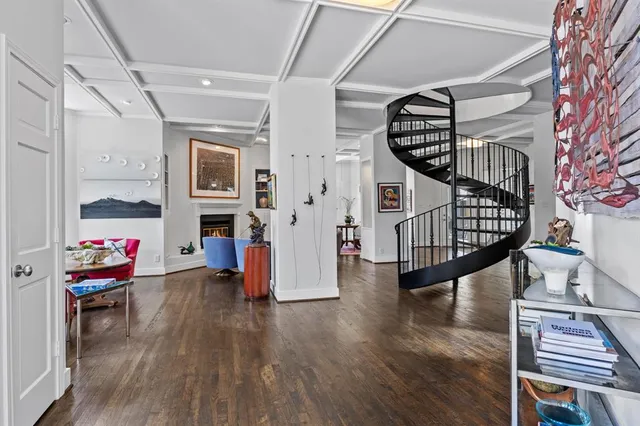 a living room with wooden floors stairs and furniture