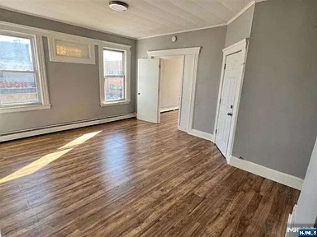 489 Market Street, Unit 2 Paterson, NJ 07501 - Photo 1 of 6 a view of an empty room with wooden floor and a window