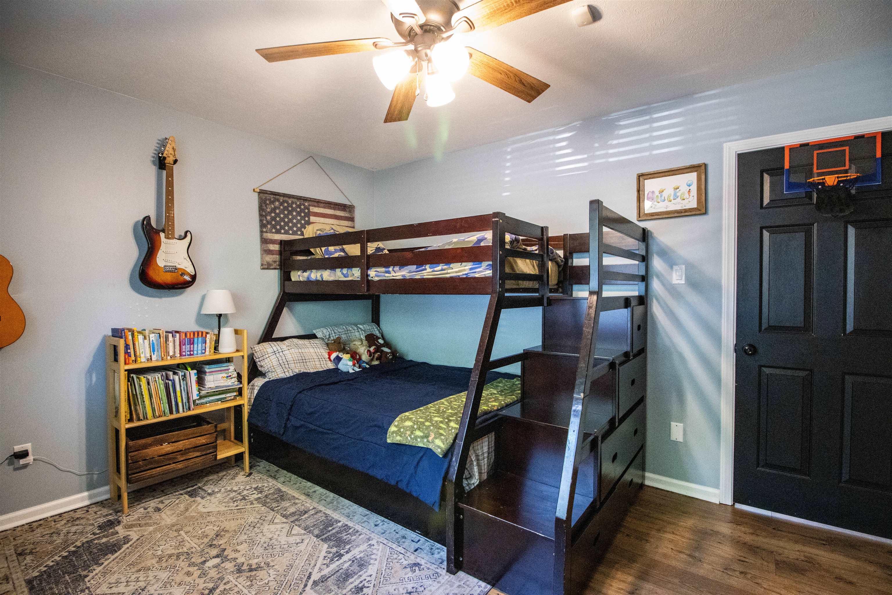 120 Craig Road Ripley, TN 38063 - Photo 21 of 38 Room featuring wood-finish flooring, a ceiling fan with light fixture, light wall paint, white baseboards, and a black paneled door