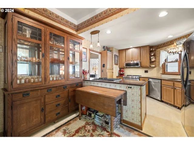 a kitchen with stainless steel appliances kitchen island granite countertop a stove a sink dishwasher and cabinets with wooden floor