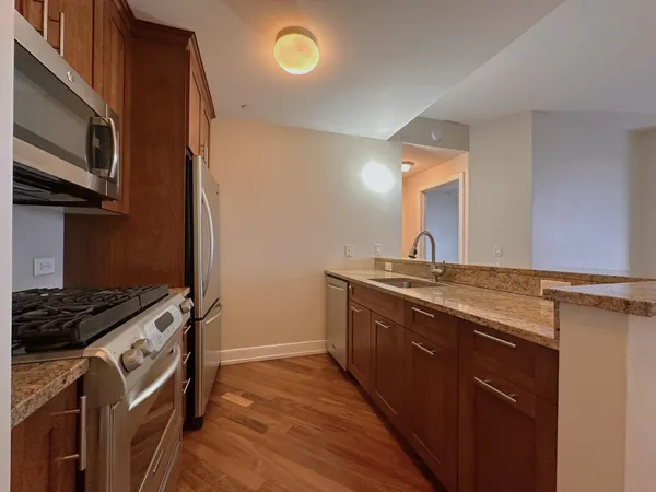 a kitchen with stainless steel appliances granite countertop a stove a sink and a refrigerator