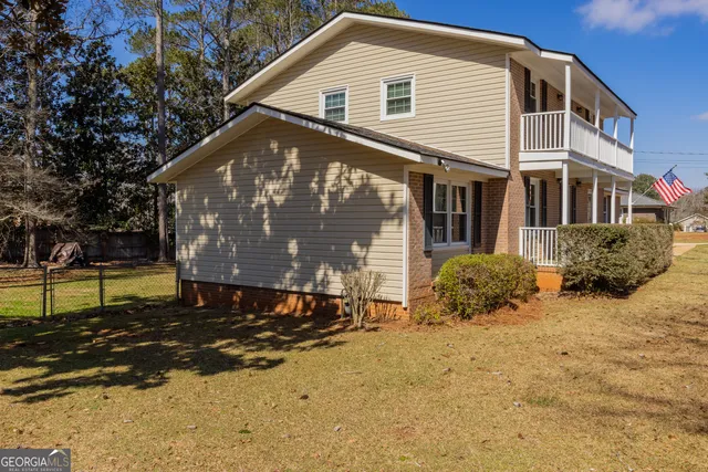 a view of house with backyard and sitting area
