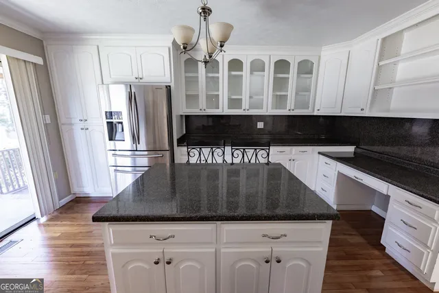 a kitchen with white cabinets and appliances