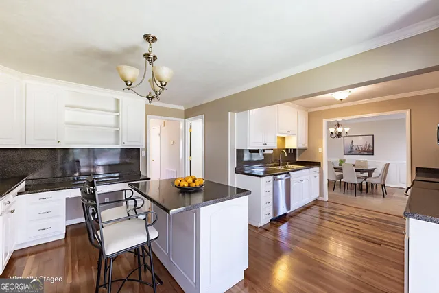 a kitchen with granite countertop white cabinets and black appliances