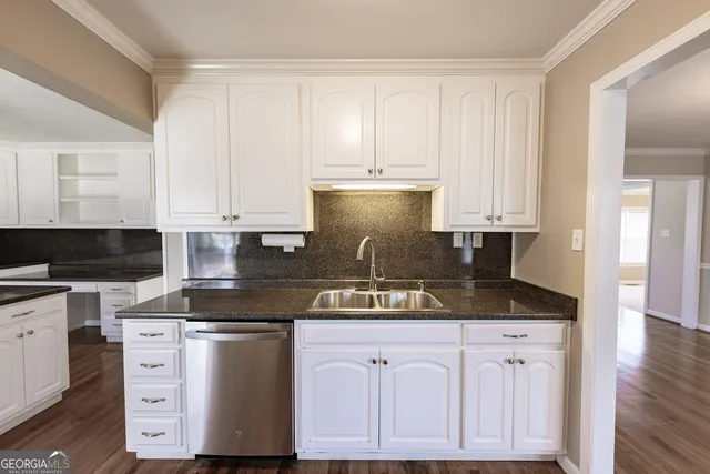 a kitchen with granite countertop a sink and a refrigerator