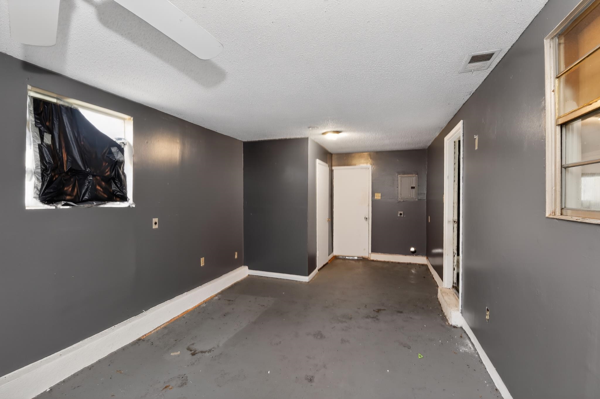 645 Parkrose Road Memphis, TN 38109 - Photo 25 of 32 Spacious interior room featuring a ceiling fan, multiple windows, a ceiling-mounted light fixture, and two interior doors