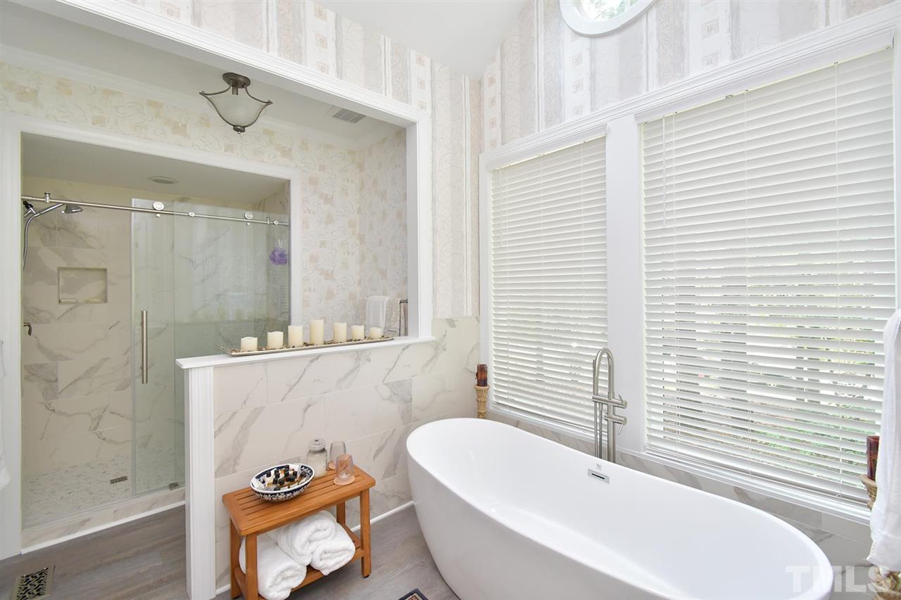 5220 Lenoraway Drive Raleigh, NC 27613 - Photo 15 of 30 Walk in shower with marble tile and large soaking tub with two large windows for natural light.