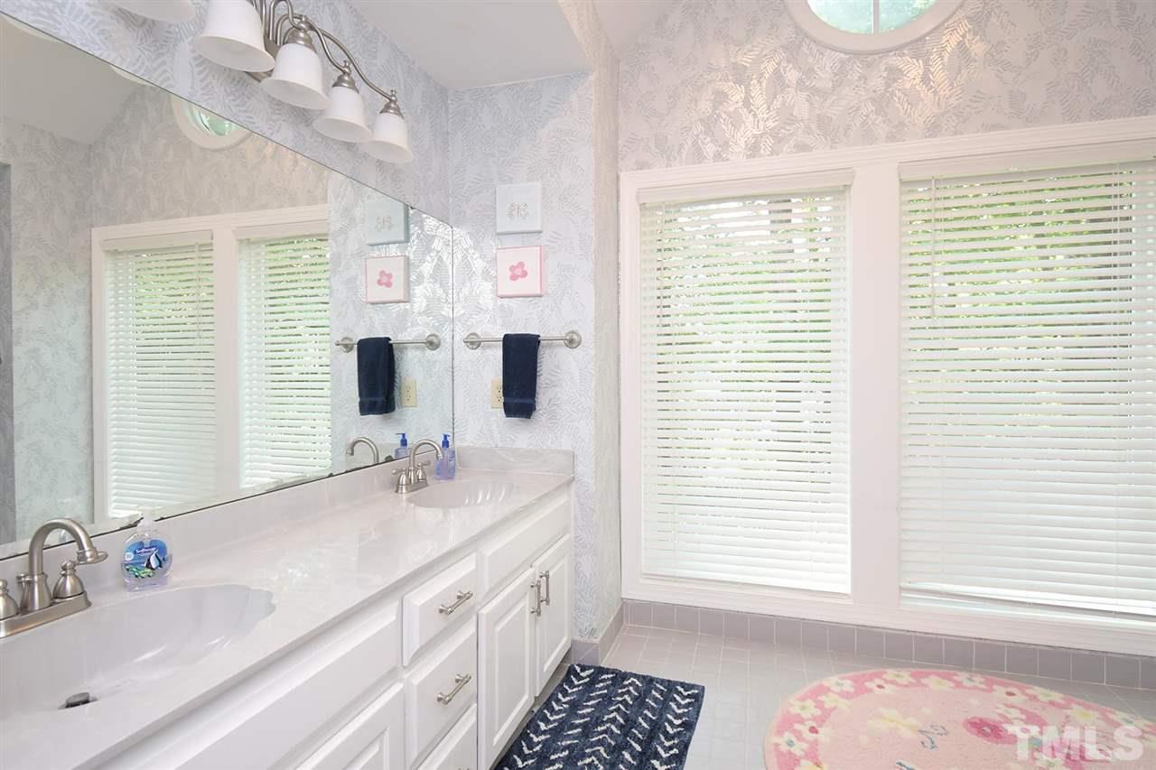 5220 Lenoraway Drive Raleigh, NC 27613 - Photo 22 of 30 Full bathroom with doorway access points from hall and Bedroom 4, dual vanity sinks, and two large windows for natural light.