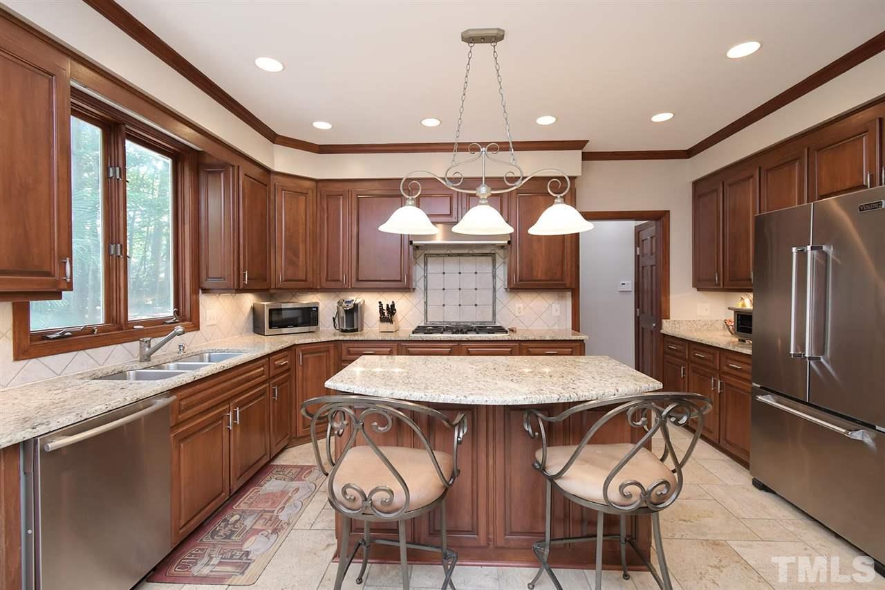 5220 Lenoraway Drive Raleigh, NC 27613 - Photo 10 of 30 Gourmet Kitchen with granite countertops, custom cabinetry, and center island with overhang for second seating area.