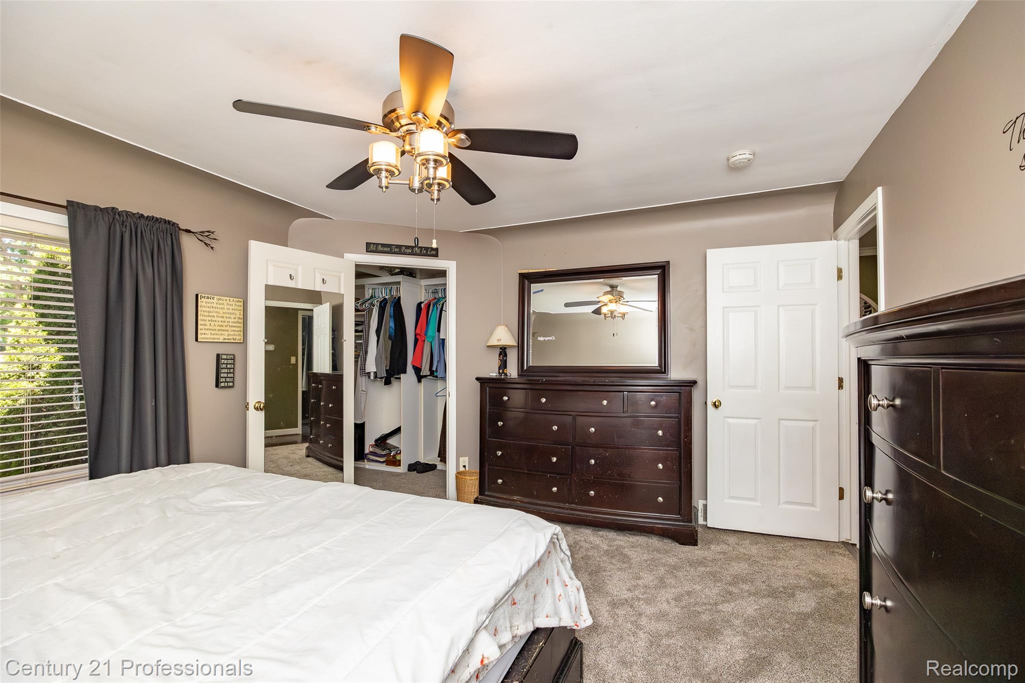 3251 Mann Road Clarkston, MI 48346 - Photo 24 of 40 Carpeted room featuring a ceiling fan with integrated lighting, a window with blinds and drapery, a paneled door, and a mirrored closet