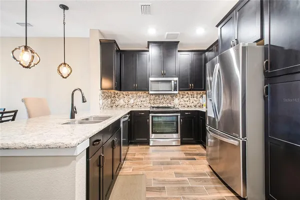 a large kitchen with a sink and stainless steel appliances