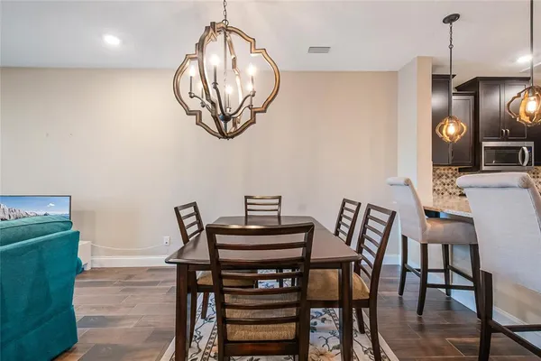 a view of a dining room with furniture a chandelier and wooden floor