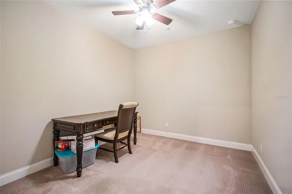 a spacious bedroom with a bed and a ceiling fan