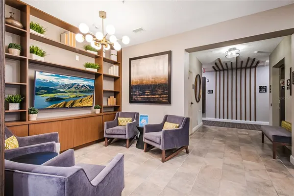 a living room with furniture a chandelier and a flat screen tv