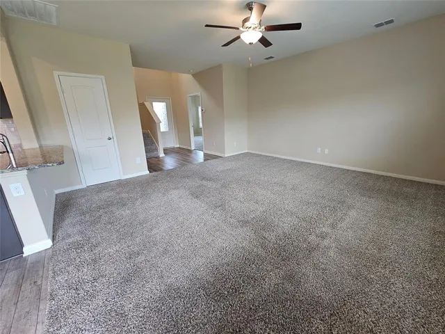an empty room with a ceiling fan and a window
