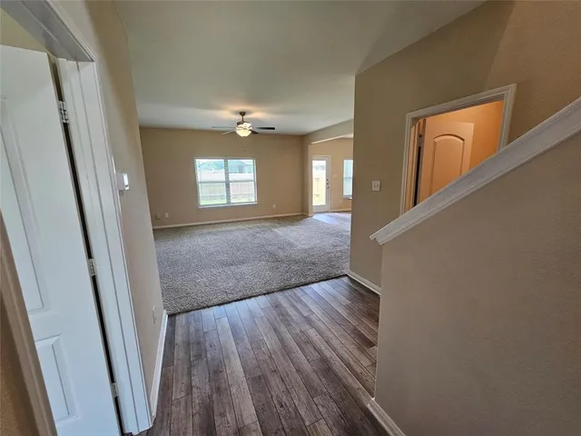 a view of a hallway with wooden floor and staircase