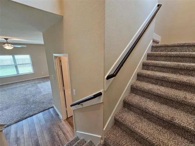 a view of a hallway with wooden floor and a living room