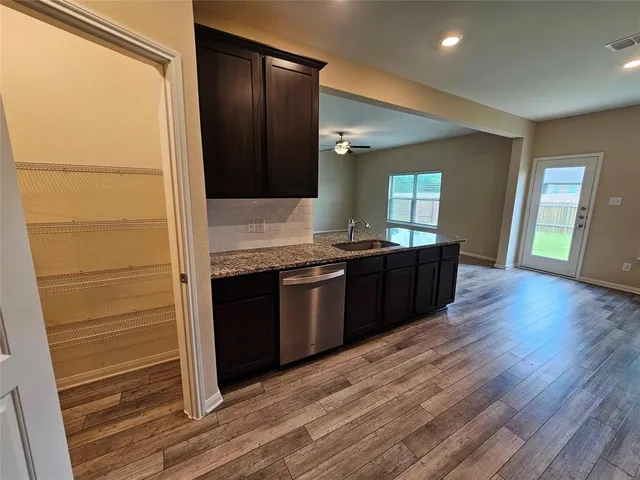 a kitchen with granite countertop a refrigerator and a sink
