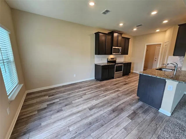 a kitchen with stainless steel appliances kitchen island granite countertop a refrigerator stove and oven