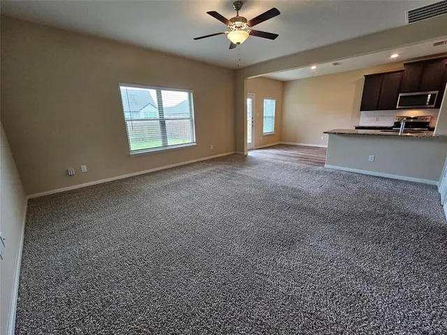a view of a livingroom with a ceiling fan and window