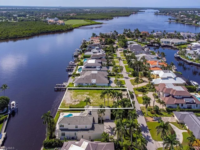 an aerial view of residential houses with outdoor space and lake view