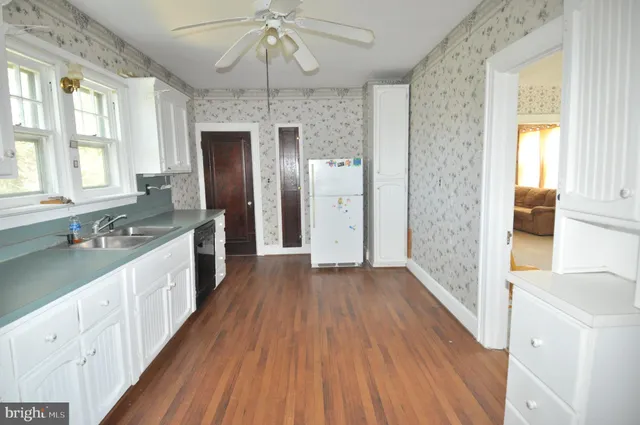 a large kitchen with a wooden floor and outdoor space