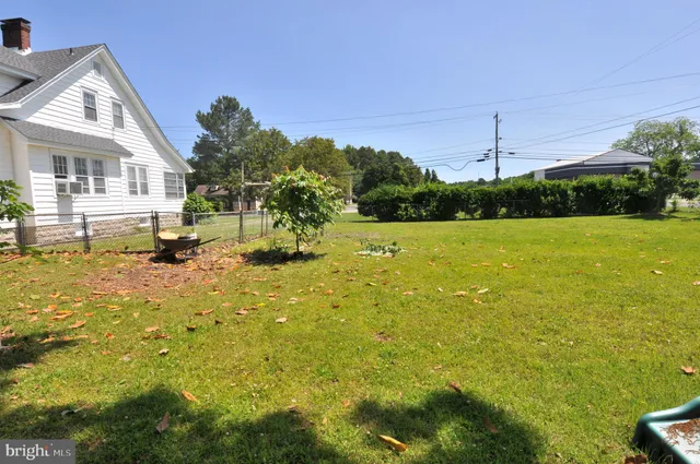 a view of a house with a big yard and large trees