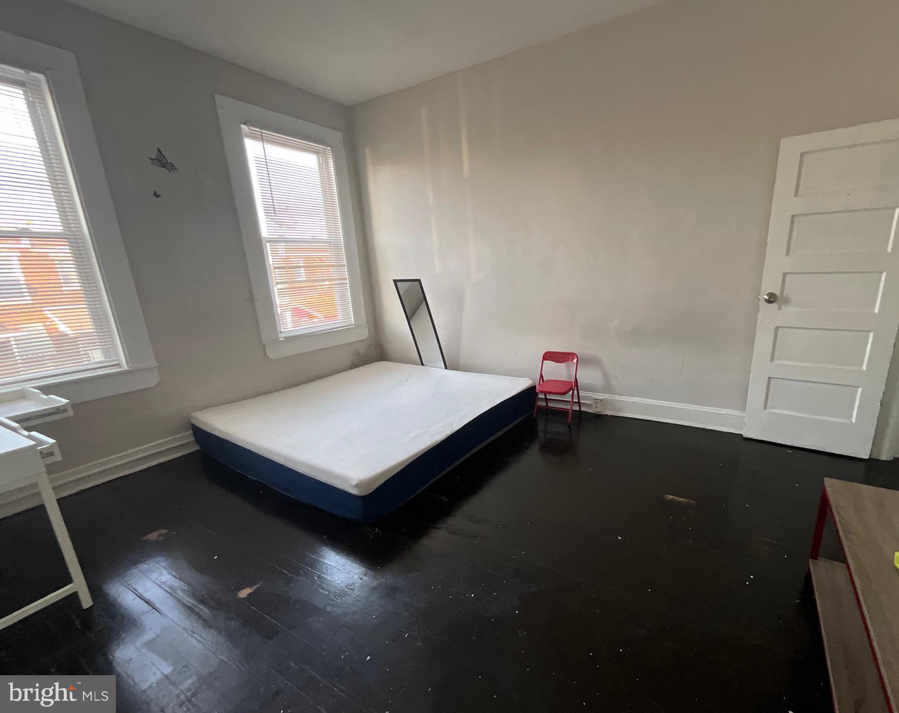 1723 East 25th Street Baltimore, MD 21213 - Photo 8 of 16 a bed sitting in a bedroom next to a window