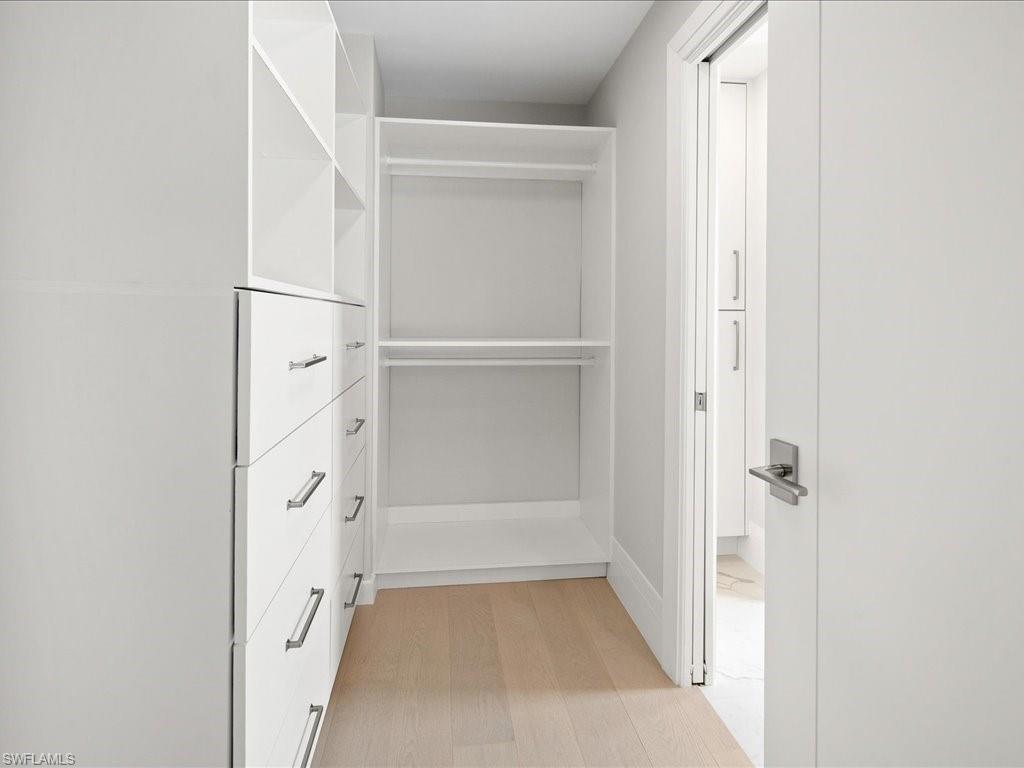 518 Cypress Way East Naples, FL 34110 - Photo 33 of 50 Walk in closet featuring light wood-type flooring