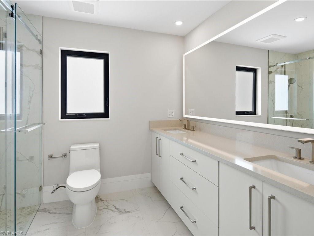 518 Cypress Way East Naples, FL 34110 - Photo 34 of 50 Full bathroom featuring a marble finish shower, marble finish floor, toilet, and a sink