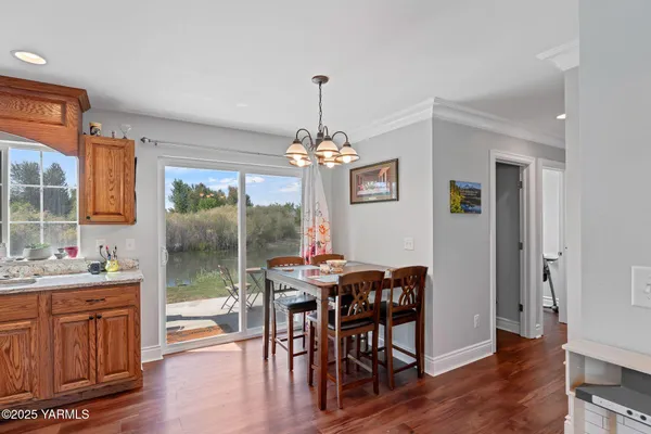 a dining room with furniture a chandelier and wooden floor
