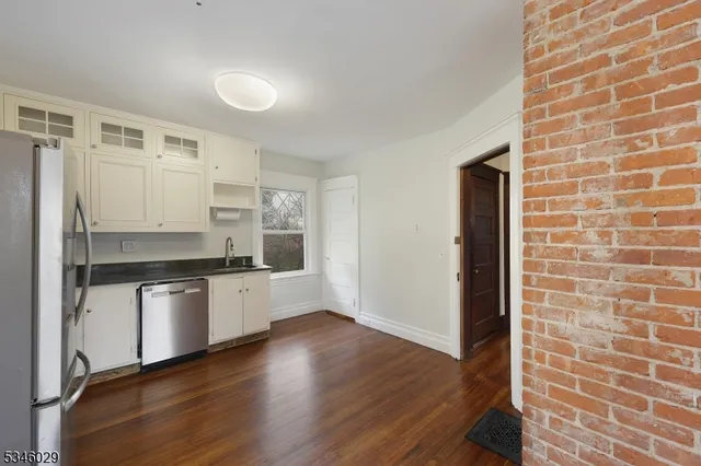 a kitchen with stainless steel appliances a refrigerator and white cabinets