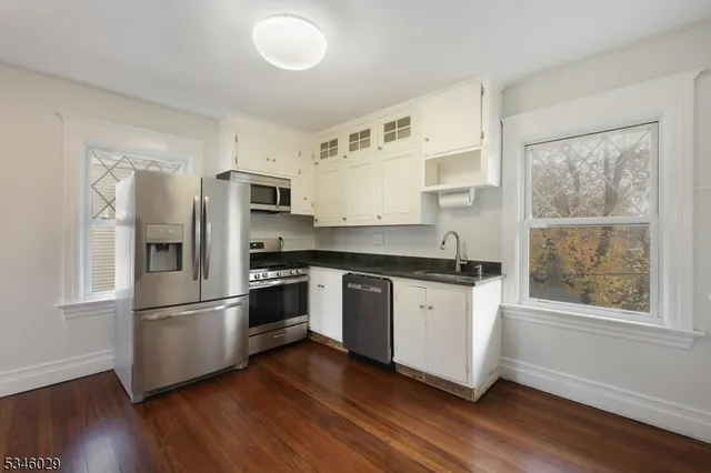 a kitchen with wooden floors and stainless steel appliances