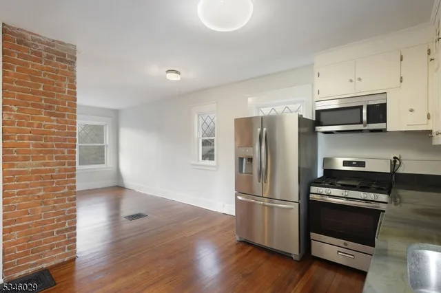 a kitchen with wooden floors and stainless steel appliances