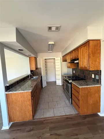a kitchen with stainless steel appliances granite countertop a stove a sink and a refrigerator