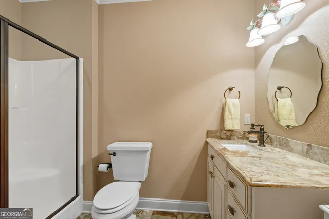 a bathroom with a sink vanity mirror and toilet