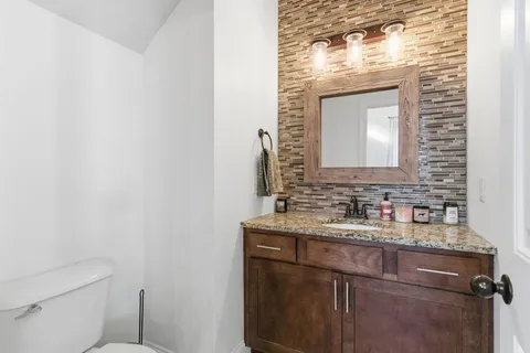 a bathroom with a toilet sink and mirror