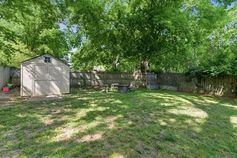 a backyard of a house with lots of green space and fountain
