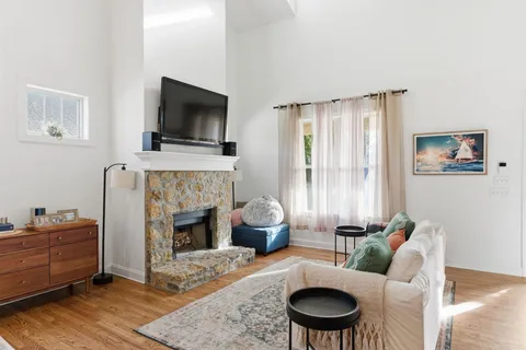 a living room with furniture a flat screen tv and a fireplace