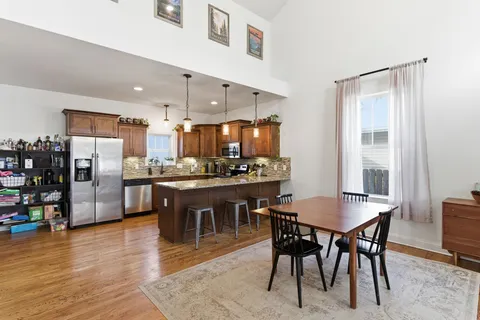 a kitchen with a dining table chairs and refrigerator
