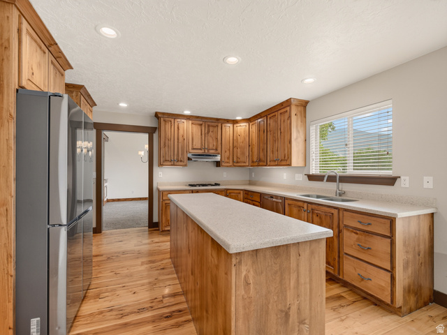 1279 West 1500th Street North Mapleton, UT 84664 - Photo 19 of 83 Kitchen featuring wood-finish flooring, natural wood cabinetry, light-toned countertops, and a stainless steel sink with a window