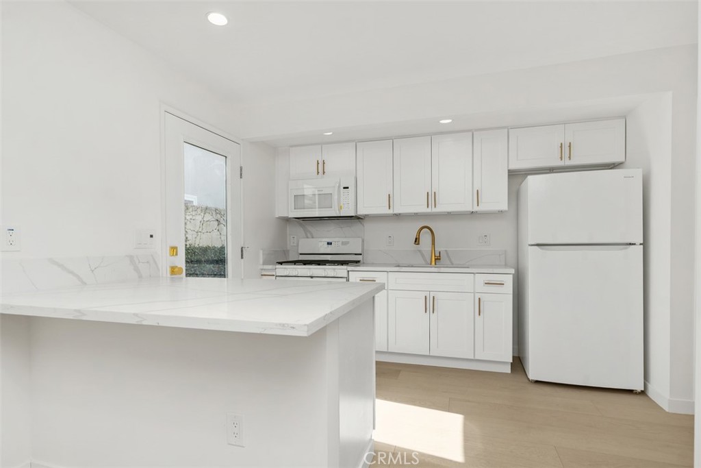 3926 Acacia Street Irvine, CA 92606 - Photo 17 of 32 a kitchen with white cabinets a sink and white appliances