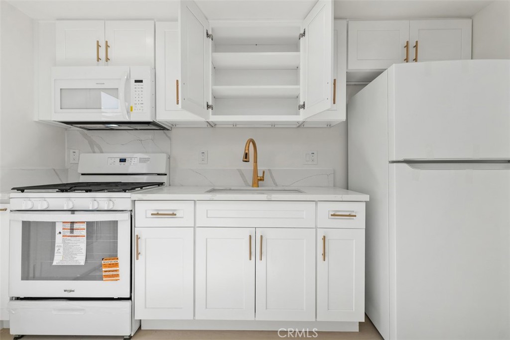 3926 Acacia Street Irvine, CA 92606 - Photo 22 of 32 a kitchen with white cabinets and white appliances