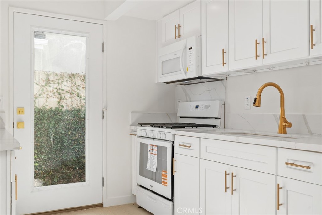 3926 Acacia Street Irvine, CA 92606 - Photo 4 of 32 a kitchen with white cabinets and white appliances